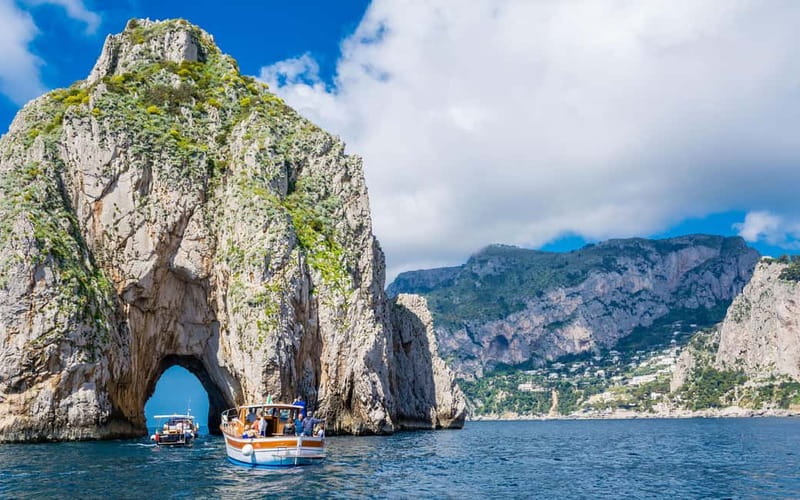 Positano: Capri Boat Tour with Swimming, Drinks, and Snacks - Approaching Capri beneath the Faraglioni